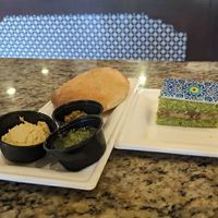 [Vegetarian] Stone-baked Moroccan Bread with Hummus, Chermoula, and Zhoug Dips, [Vegetarian] Pistachio Cake at Walt Disney World - Tangierine Café in Lake Buena Vista