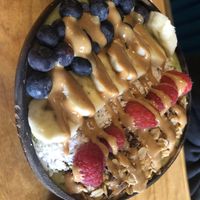Smoothies bowls : tropical green (spinach, mango, pineapple, banana ) then fresh berries, banana slices, coconut flakes, cacao nibs , hemp hearts & peanut butter drizzle   at Lightbox Cafe in Philadelphia
