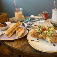 Vegan cheese and onion chutney panini and “the vegan one” waffle. Oat milk pumpkin spiced iced coffees at the back    at ComiCoffee in Newport