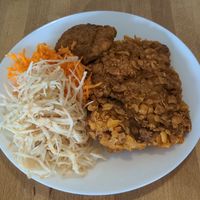 Tofu skin steak alongside cabbage and carrot salads at Vega in Warsaw