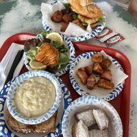 Single (amazing) vegan krab cake, absolutely delish vegan cheezy grits, vegan beignets, vegan krab po boy, potatoes came with    at Meals From The Heart Cafe in New Orleans