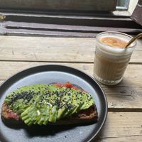Tostada con tomate, aguacate, sésamo y AOVE + iced chai latte con leche de avena  at Slow Café in Madrid