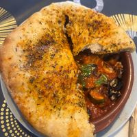 Veg in a tomato sauce baked under soft, fluffy pitta  at Paprika in Valencia
