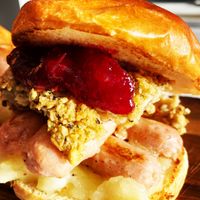 Xmas special double sausage ,sage and onion stuffing, homemade cranberry sauce in a vegan brioche Bun  at Greedy Vegan in Chelmsford