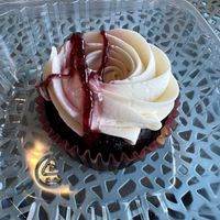 Chocolate Cupcake with vanilla frosting and raspberry drizzled on top   at The Mindful Table in Perrysburg