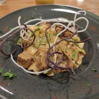 Rice noodles with glazed home-made tempeh, various fresh vegetables, coriander and other herbs, crispy noodles, in a creamy soy sauce. It was excellent.  at Avocado in Athens
