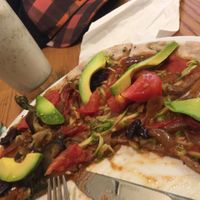Vibrant vegan pizza and coconut milkshake at Avocado in Athens