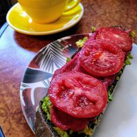 Latte + rye bread with avocado, beetroot hummus and tomatoes at Massay in Granada