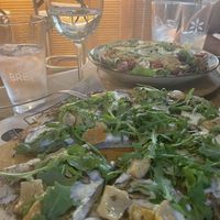 Vegan and gluten free pizza. In the back there’s a salad with heura  at Bresca in Madrid