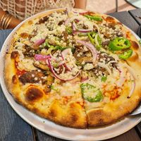 Pizza with vegan cheese, mushrooms, red onions and jalapeños at Pizza Rustica in Miami Beach