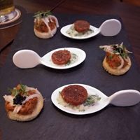 Appetizer of vegan caviar and eggplant toastie and a bean sausage on a herbed yogurt. at Lucky Leek in Berlin