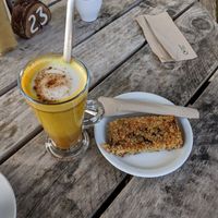 Turmeric oatmilk latte and vegan apricot pumpkin seed flapjack at Pillars of Hercules Organic Farm Shop and Cafe in Falkland