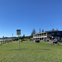 The grass with tables in front of the kiosk at Kiosk Lennox Beach in Lennox Head