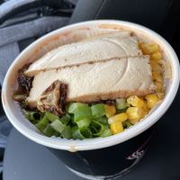 Cup of ingredients ready to be added to the broth underneath.  at Kotsu Ramen & Gyoza in Montclair