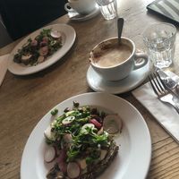 big cappucinos w a glass of water included  at Café des Amis in Zurich