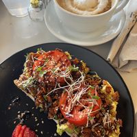 VLT avocado toast with coconut bacon 😋 and oat milk cappuccino. The vibe was mellow and inclusive. My new favorite coffee house!  at FeelLove Coffee in Loveland