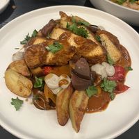 Tofu Cacciatore: Roasted savory tofu cutlet stewed with onions, peppers, fingerlingpotatoes, olives, & eggplant variations in black garlic sauce, topped with fresh herbs  at Gladys  in Edgewater