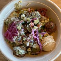 right rice, roasted eggplant, hummus, harissa, falafel, salt pickles, lentil tabbouleh, pickles onions, tomato cucumber salad, cabbage slaw, lemon herb tahini  at CAVA in Fayetteville