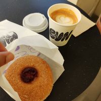 Flat white with grape jam and custard doughnut at Bun and Coffee in Malaga