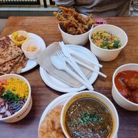 From top clockwise; okra fries, mung chapata, currywurst koftas, chole saag, raghda pethis and aloo gobi paratha at Bundobust - Oxford St in Manchester