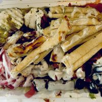 Chick’n on top of a salad that had lettuce, tomatoes, olives, dolmas and white sauce I added pickles and 1/2 a pita which they cut into strips and laid on top. Great idea!!!  at Vegan On The Fly in New York City