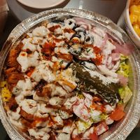 Grape leaf, jerk 🐔 on top of rice and salad w/ white sauce and hot sauce. 🔥 at Vegan On The Fly in New York City