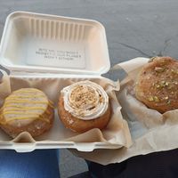 De izquierda a derecha: donut de mermelada de mango y frutos de la pasión, bomba de chocolate y avellanas y donut de pistacho at Areca Bakery in Barcelona