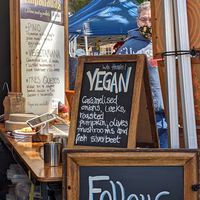 a sign with a description of what's in it and featuring a man (not vegan) at Cantina Latina in Battery Point