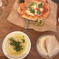vegan: classic hummus with pita bread. next to the pizza magherita with parmesan on it (😠)  at Esh Pitabar in Amsterdam