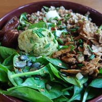 Bowl with whole grains, spinach, hummus, dates, sour cream and Seitan. at De Bon'heur in Marseille