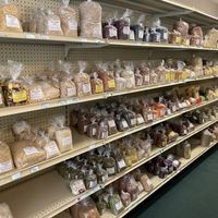Aisle of bagged bulk items, each with labels featuring a Bible verse at Pure N Simple in Glens Falls