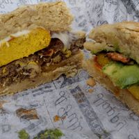 Egg, Bacon, Avocado, and Aioli Sandwich and Sausage, Egg, and Cheese Biscuit cut in half at Dulce Vegan Bakery and Cafe in Atlanta