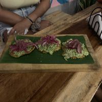 Tostones w smashed avo & lime pickled onion No feta  at Jungle SV in El Tunco
