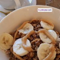 Granola bowl with soy yogurt, granola, banana, coconut flakes and peanut butter at Lampadina in Bologna
