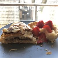 Half of almond croissant and half of a fruit tart  at Lazy Cow Bakery in Seattle