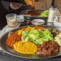 Vegetarian combination platter plus mushroom tibs and buticha. Mug of soy chai latte. at Messob Ethiopian Restaurant in Oakland