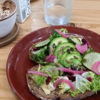 Avocado and hummus toast with pickled onions and cucumber. at Ananás Brunch in Sevilla