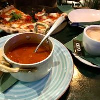 Delicious tomato soup with pita bread, soy milk cappuccino and vegetarian pizza. at KAFKA Hummus Café  in Prague