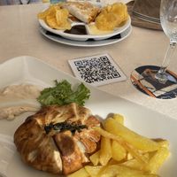 In the foreground is my crunchy spinach with vegan cheese. It was a pie and came with lettuce and chips, plus a smear of something that was a cross between hummus and mayo.   at Restaurante Seis Perlas in El Campello