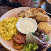 Vegan scrambled eggs with fried rice balls, grilled tomato, salad, toasted bread and spiced yogurt/cream 😋  at Cinnamon & Co in West End