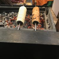 Vegan chimney roasting over coals - one with choc chips and the other with sugar and cinnamon cooking away. at Vegan Garden Budapest in Budapest