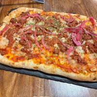Pinsa con mozzarella y boloñesa veganas  at LaMundi in Cordoba