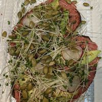 Beat hummus and avocado toast with close-up of the pepitas at Spirulina in Montreal