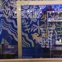 Hours and the HappyCow logo at Varuna Plant-Based Food & Juice Bar in Manuel Antonio