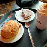 Vegan sausage bap, cheesecake and mocha with vegan whipped cream at Caffè Nero in Carlisle