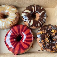 Clockwise from top left: vanilla espresso, Boston cream, chocolate with coconut 'bacon', strawberry blueberry at Dough House Vegan Donuts in Black Mountain