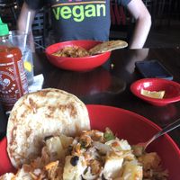 Bowl filled with veggies, pineapple, BBQ tempeh & sweet & sour sauce   at Flat Top Grill in Mishawaka