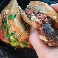 [Vegan] Root Burger: red quinoa & roasted beet "burger" on an oat-topped wheat bun with lettuce, tomato, red onion, garlic dill pickles, veganaise, and sprouts at Blatt Beer & Table - S 170th Plaza in Omaha