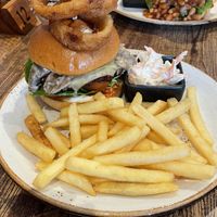 Two stacked burgers with fries, onion rings and coleslaw .  at Huggers in Norwich
