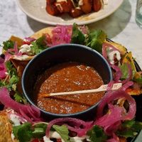 Harissa patatas bravas with tahini cream + Nachos with black bean mole, charred salsa roja, pink pickled onion at Mildreds - Covent Garden in London